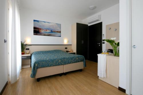 um quarto com uma cama com um cobertor azul em Hotel Al Fogo em Bevazzana