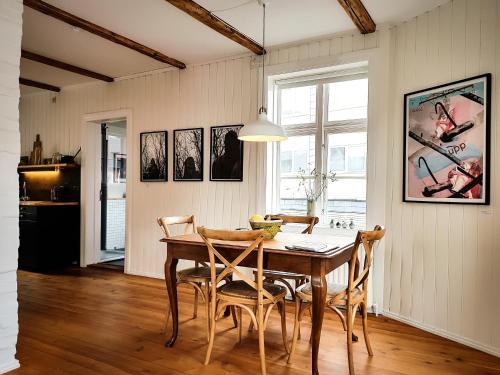 een eetkamer met een houten tafel en stoelen bij House of the Snowbird in Reykjavík