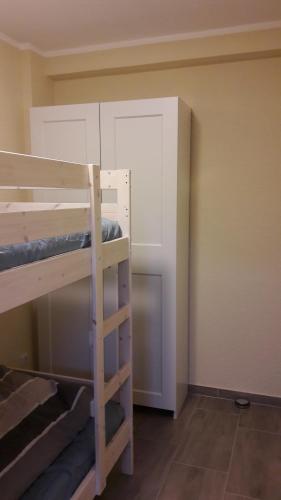 a room with two bunk beds and a door at Küstenhuus-Katy in Glowe