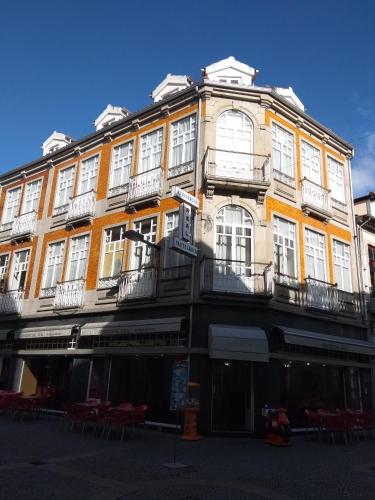 a large yellow building with white windows on a street at Residencial Real - Antiga Rosas in Vila Real