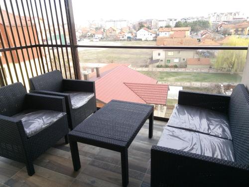 a balcony with chairs and a table and a large window at Anja in Bijeljina