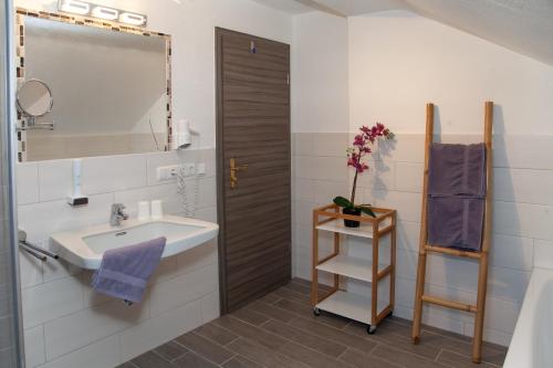 La salle de bains est pourvue d'un lavabo et d'un miroir. dans l'établissement Pension Bavaria, à Mittenwald