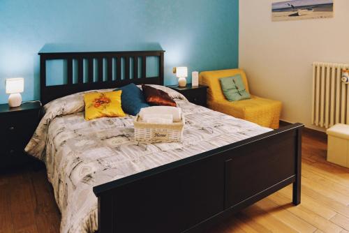 a bedroom with a large bed and a chair at Agorà Bisceglie in Bisceglie