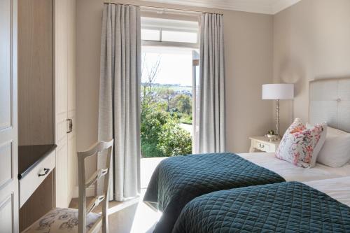 a bedroom with a bed and a large window at De Zalze Winelands Golf Lodge 6 in Stellenbosch