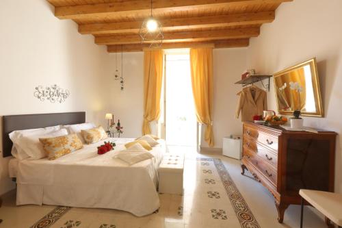 a bedroom with a bed and a dresser and a window at "Suliscenti" Dimora Siciliana B&B in Avola