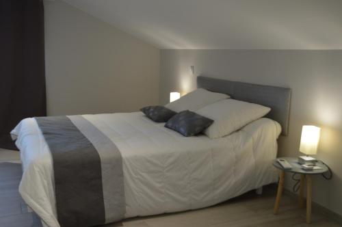 ein Schlafzimmer mit einem Bett mit zwei Kissen darauf in der Unterkunft Villa au coeur du Gers avec vue sur les Pyrénées in Caumont
