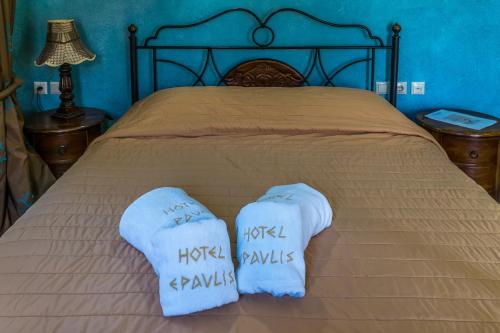 a bed with two white socks on top of it at ''EPAVLIS boutique GALAXIDI'' in Galaxidhion