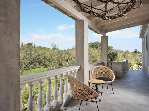 eine Veranda mit 2 Stühlen und einem Kronleuchter in der Unterkunft Casa di Pierro in Lithakia