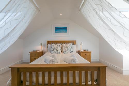 a bedroom with a bed with white walls at Sea Ayr in St Ives