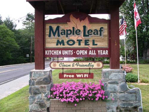 a sign for a magic leaf motel with pink flowers at Maple Leaf Motel in Littleton