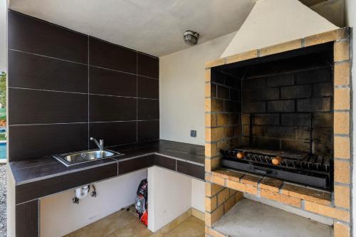 a kitchen with a sink and a fireplace at Villa Aigües Blanques in Es Figueral Beach