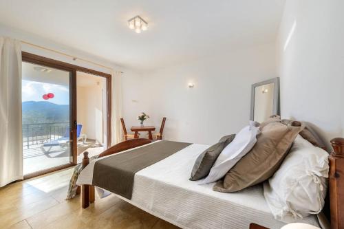 a bedroom with a bed with a view of a balcony at Villa Aigües Blanques in Es Figueral Beach