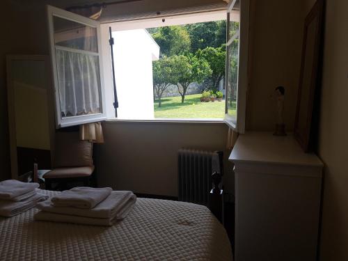 a bedroom with a bed and a window with towels on it at Cozy Villa Cristelo - Family & Friends in Cristelo