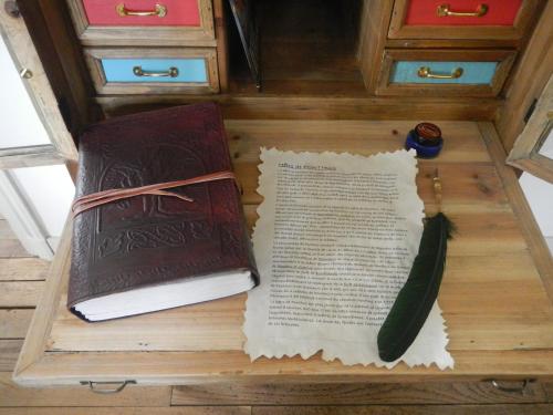 zwei Bücher, die auf einem Holztisch mit einem Buch sidx sidx sitzen in der Unterkunft Le Presbytère de Saint Malon in Saint-Malon-sur-Mel