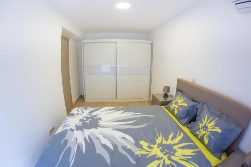 1 dormitorio con 1 cama con sábanas azules y amarillas en Central Budva apartment, en Budva