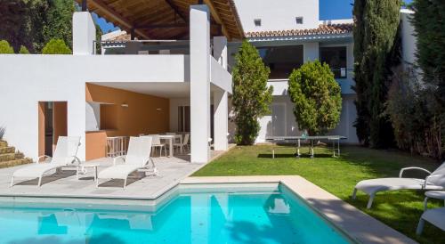 uma villa com uma piscina e uma casa em VILLA ALOHA GOLF em Marbella
