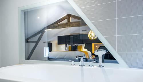 a bathroom with a mirror above a white sink at Logis Hôtel Le Tilia in Joux