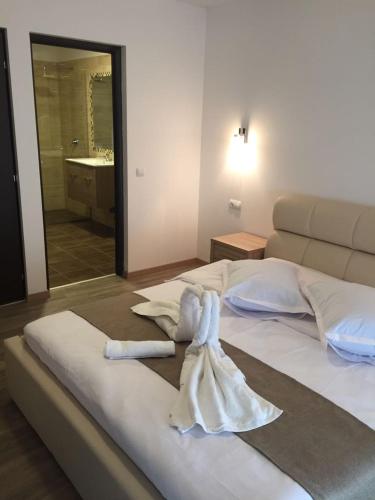 a bedroom with a bed with a towel on it at Pensiunea OK in Vişeu de Sus