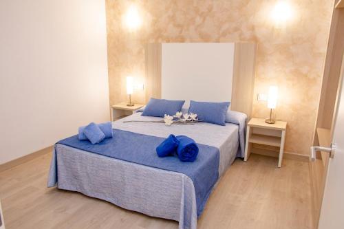 
a bedroom with a bed and a dresser at Apartamentos Maribel in Cala Blanca
