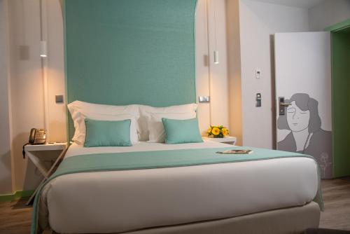 a bedroom with a large bed with a painting on the wall at Be Poet Baixa Hotel in Lisbon