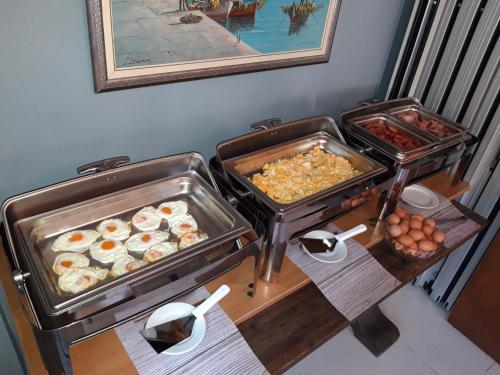 a buffet with eggs and other food on a table at Grand Olympic Hotel Loutraki in Loutraki