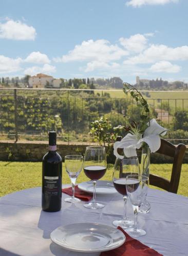 a table with wine glasses and a bottle of wine at Villa Il Fedino in San Casciano in Val di Pesa