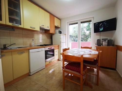 a kitchen with a table and chairs and a kitchen with yellow cabinets at Comfortable 3* Apartment Lapad Center in Dubrovnik