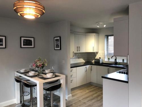 a kitchen with white cabinets and a table with flowers on it at City Centre Townhouse-3 Bedrooms & Parking - Excellent Location in Belfast