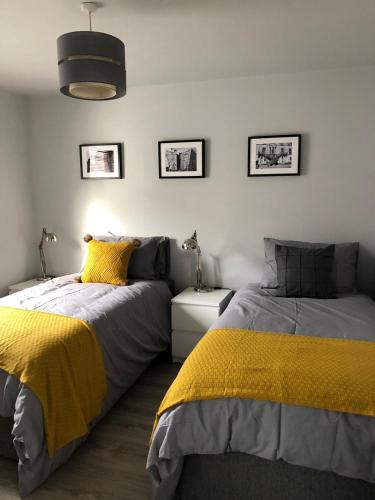 two beds in a bedroom with yellow and grey at City Centre Townhouse-3 Bedrooms & Parking - Excellent Location in Belfast