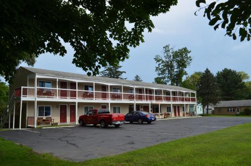 a building with a red truck parked in a parking lot at Cozy Corner Motel in Williamstown