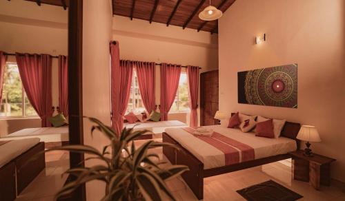 a bedroom with two beds and a plant in it at Bohemian Hotel - Negombo in Negombo