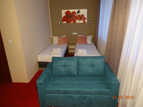 a small room with two beds and a couch at Carina Hotel in Tczew
