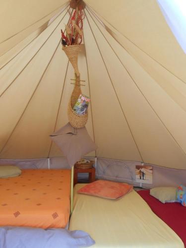 une chambre avec deux lits dans une tente dans l'établissement Les Soleillas pour votre zen'ittude, à Chalencon