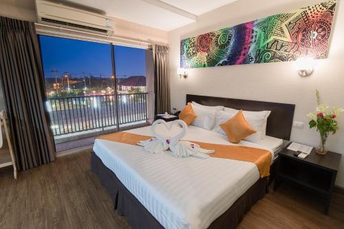a hotel room with a bed with a large window at The Cotai Luxury Design Hotel in Bang Bo
