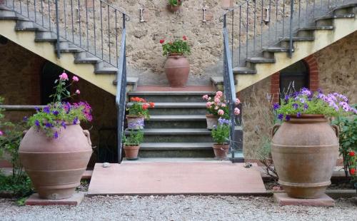 a stairway with pots of flowers on the stairs at Antico Podere Il Bugnolo in Poggibonsi