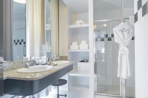 a bathroom with two sinks and a shower at Proximity Hotel in Greensboro