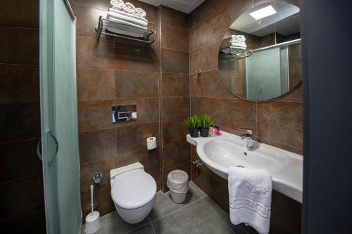 a bathroom with a toilet and a sink and a mirror at Tourist Hotel in Antalya