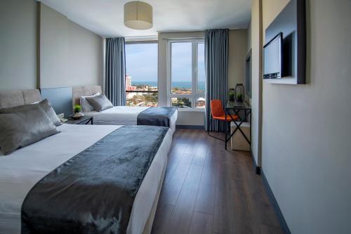 a hotel room with two beds and a window at Tourist Hotel in Antalya