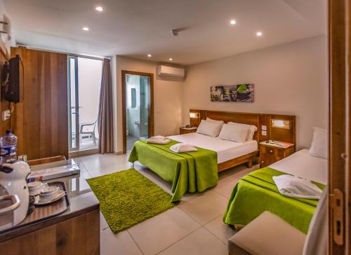een hotelkamer met 2 bedden en een raam bij Cerviola Hotel in Marsaskala