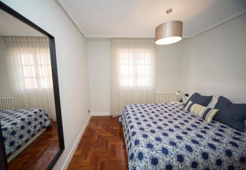 Schlafzimmer mit einem Bett und einem Spiegel in der Unterkunft La Casa de Julia puerto playa in Lekeitio