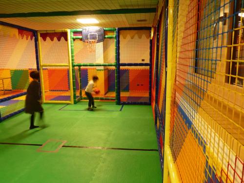 two children playing in a gym with a basketball hoop at Hotel Select in Andalo