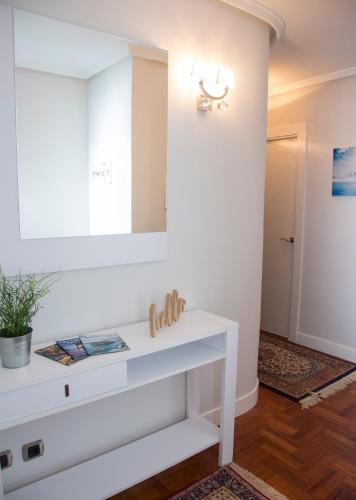 a bathroom with a white sink and a mirror at La Casa de Julia puerto playa in Lekeitio