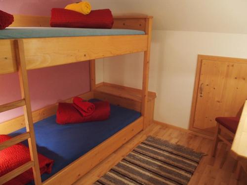 a bunk bed with two red pillows on the bottom bunk at Dorfergut in Weisspriach
