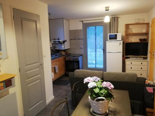 a living room with a couch and a table with flowers at la petite maison 05 in Trescléoux