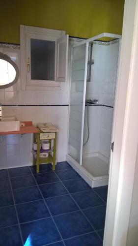 baño con ducha y suelo de baldosa azul. en Alborada De San Juan, en Beleño