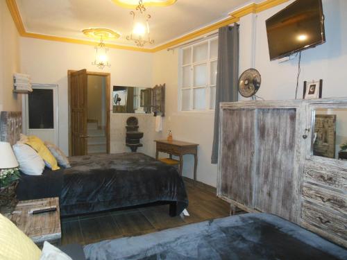 a bedroom with a bed and a tv on the wall at Casa El Ombligo de la Luna in Guanajuato