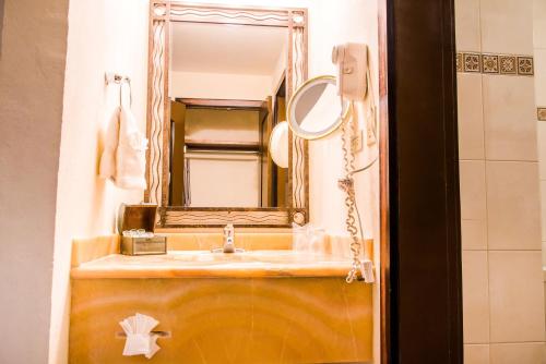 La salle de bains est pourvue d'un lavabo et d'un miroir. dans l'établissement Hotel María Bonita Consulado Americano, à Ciudad Juárez