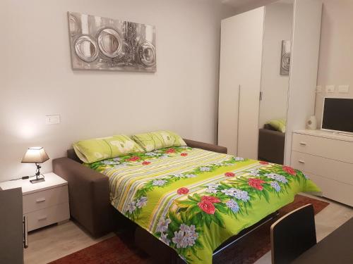 - une chambre avec un lit et une couverture colorée dans l'établissement Monolocale direttamente sul lago, à Verbania