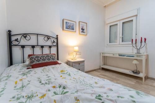 sypialnia z łóżkiem, biurkiem i oknem w obiekcie Apartamento del Pescador de Cádiz w Kadyksie