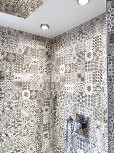 a bathroom with a shower with a tiled wall at Bed No Breakfast AK in Naples